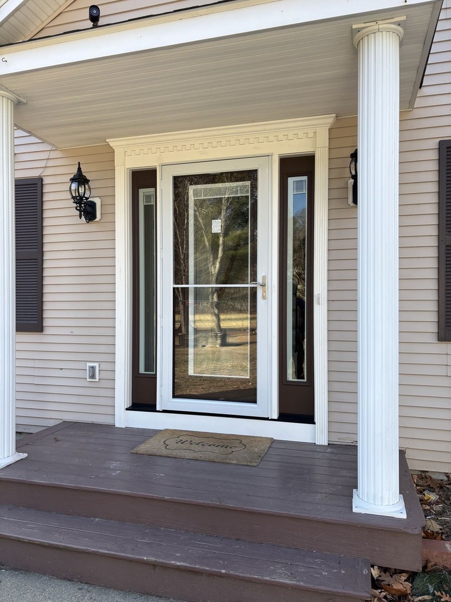 Front entry with glass storm door, sidelights, and columns at a Central Connecticut home by Riverbend Renovations