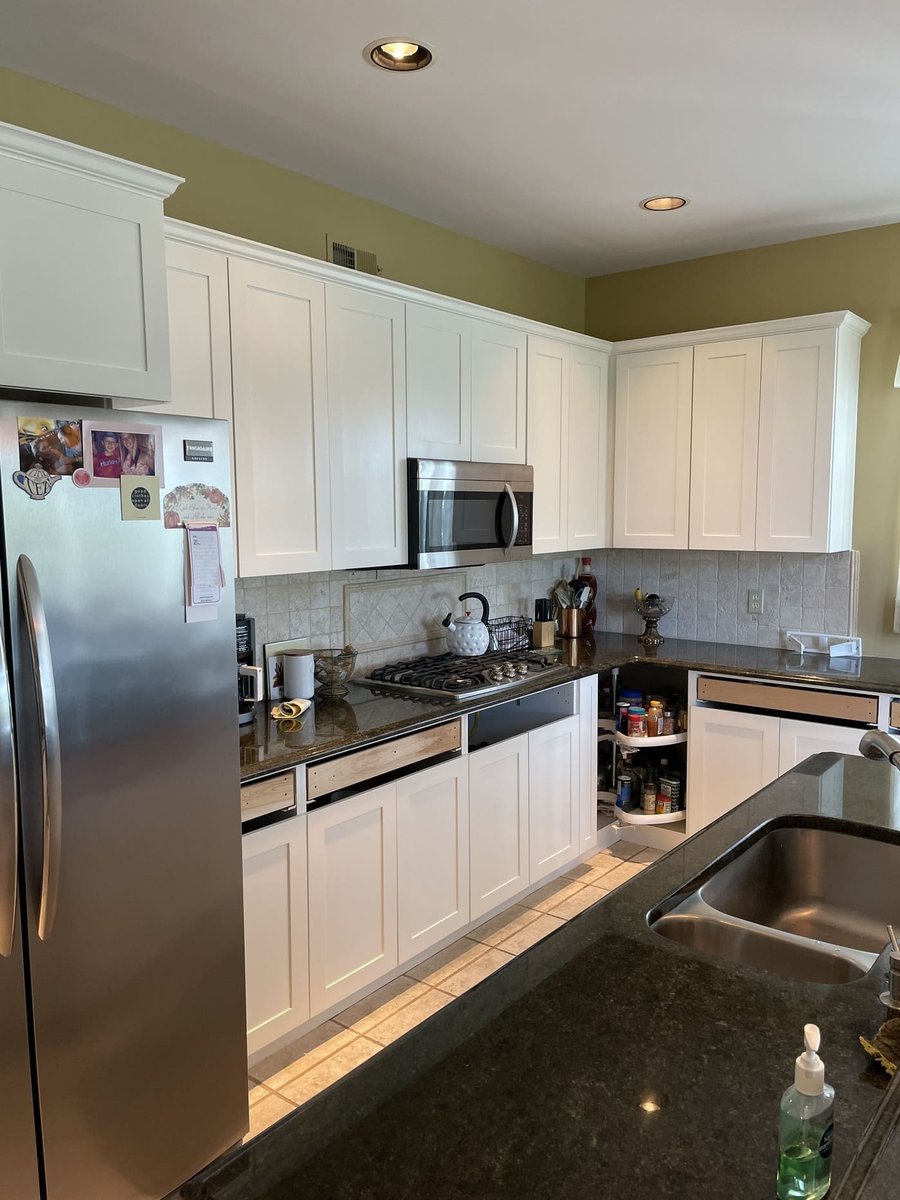 Kitchen with white cabinets, granite counters, and stainless appliances in a Central Connecticut home by Riverbend Renovations