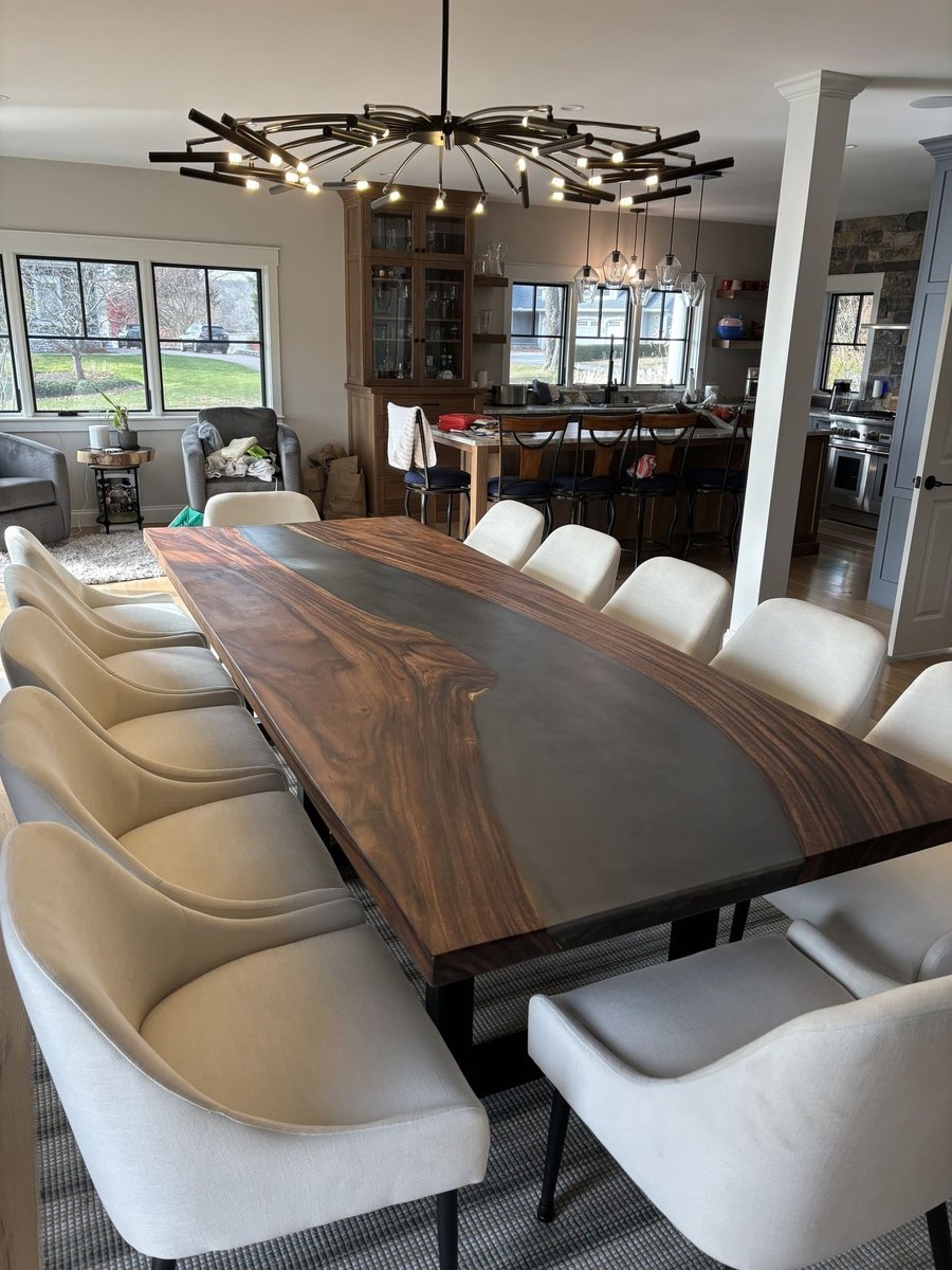Live edge dining table under modern chandelier in a Central Connecticut home by Riverbend Renovations