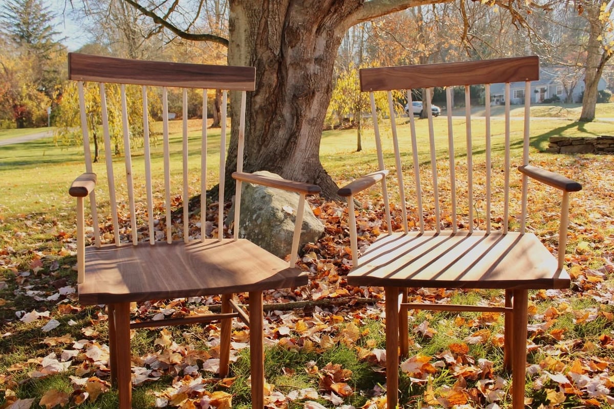 Pair of handcrafted wood chairs under tree with autumn leaves outside a Central Connecticut home by Riverbend Renovations
