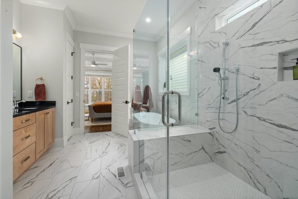 Bathroom remodel with glass shower, marble tile, vanity, and view into bedroom in Tolland, CT