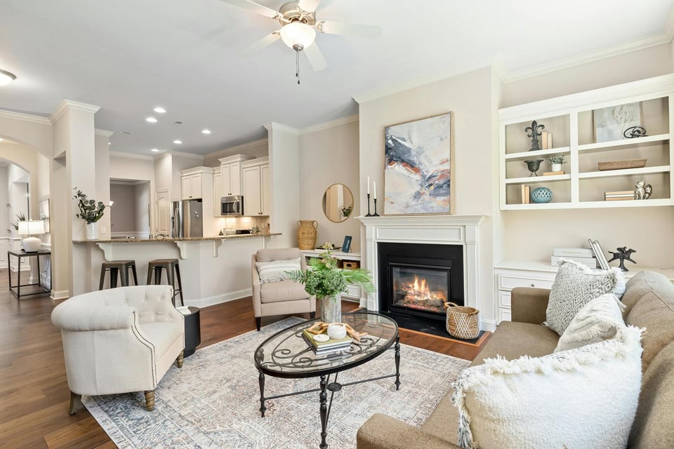 Stock image of bright living room with fireplace, built-ins, and open kitchen in Central Connecticut