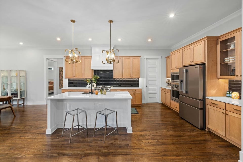 Stock image of spacious kitchen with island, pendant lights, wood cabinets, and stainless appliances in Colchester, CT